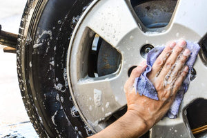 Male hand washing a wheel.