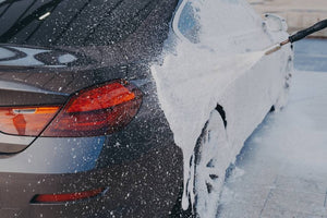 Pressure washing a car’s exterior.