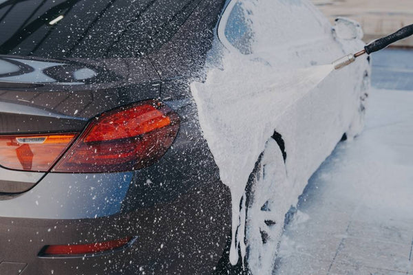 Pressure washing a car’s exterior.