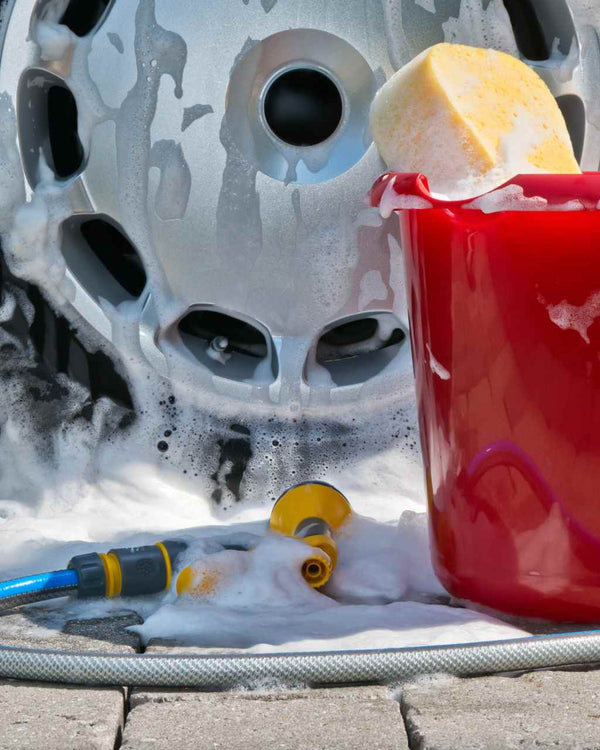 Soapy bucket next to a soapy wheel.