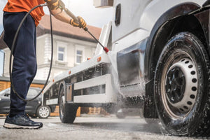 Truck owner spraying down his truck.