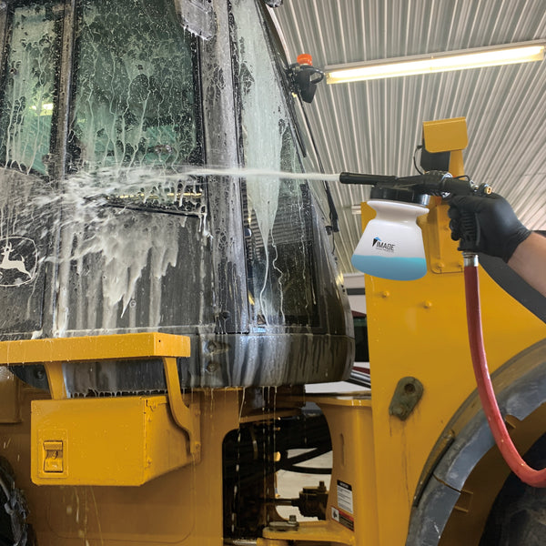 Garden foamer foaming onto yellow tractor