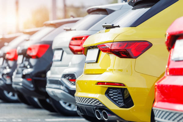 A row of cars in a dealership lot.