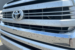 Bug splatter on front car grille. Bug splatter removal from car grille without paint damage.