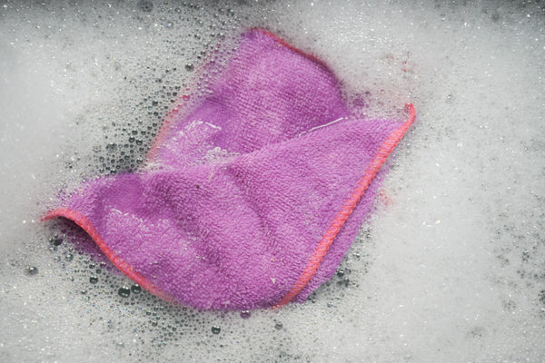 Purple Microfiber being hand washed in soapy water.