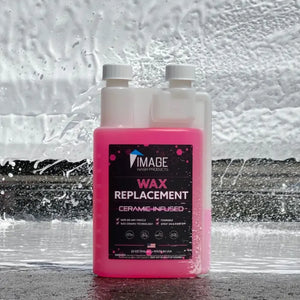 Pink bottle of Image Wash Products Ceramic Wax Replacement with a car wash background