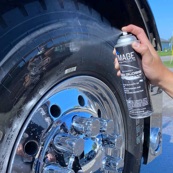 Semi tire being sprayed with a can of High Gloss Protectant