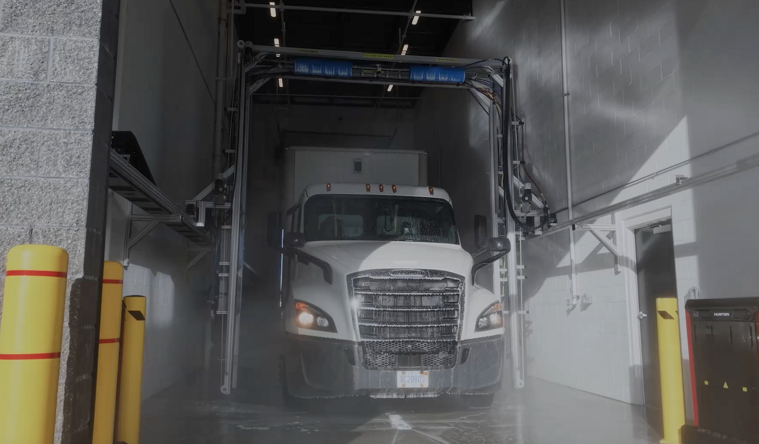 White semi truck driving through an IQ Max large vehicle wash system from Image Wash Products.