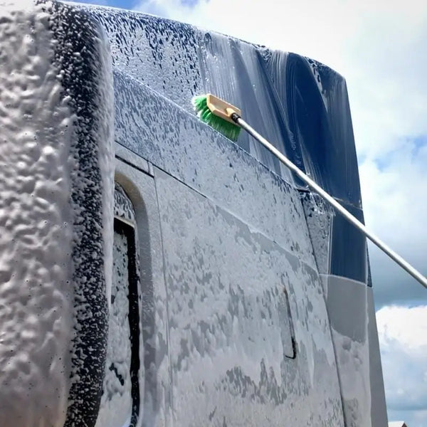 Semi truck covered in platinum wash foam being brushed with a dual sided synthetic brush on a 12' pole.